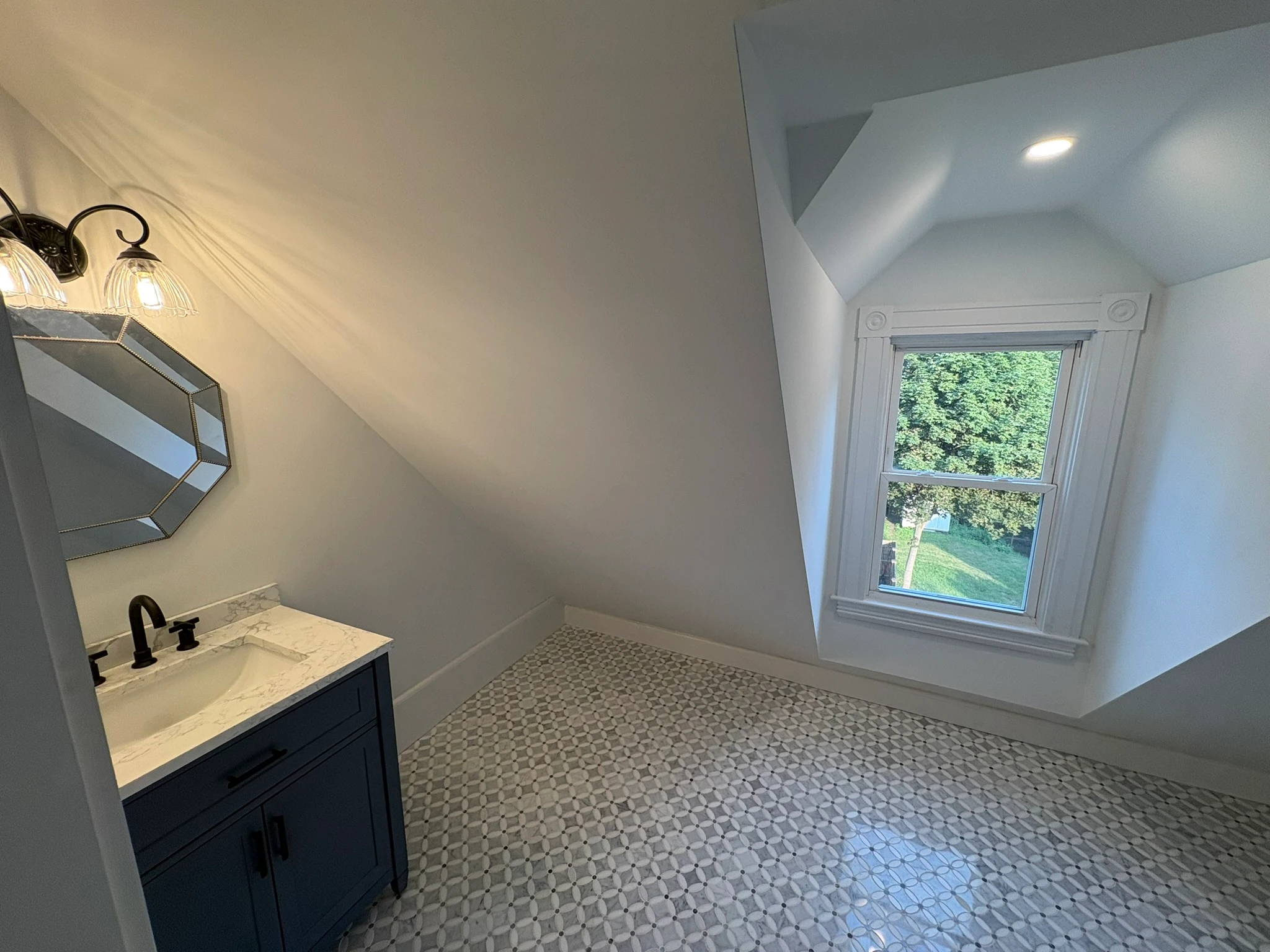 Attic bathroom with blue vanity under the sloped roof