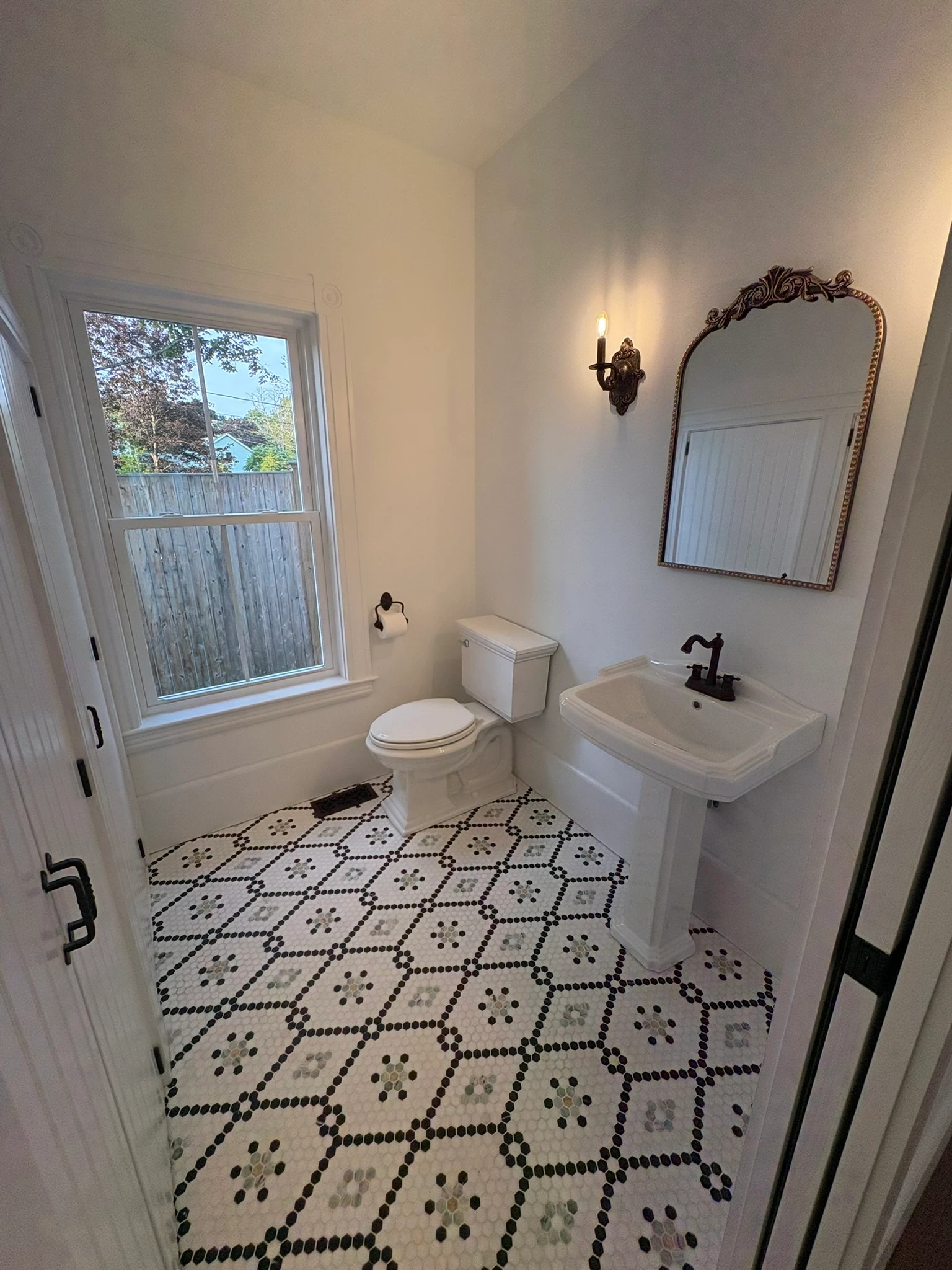 The powder room — patterned hex tile and pedestal sink