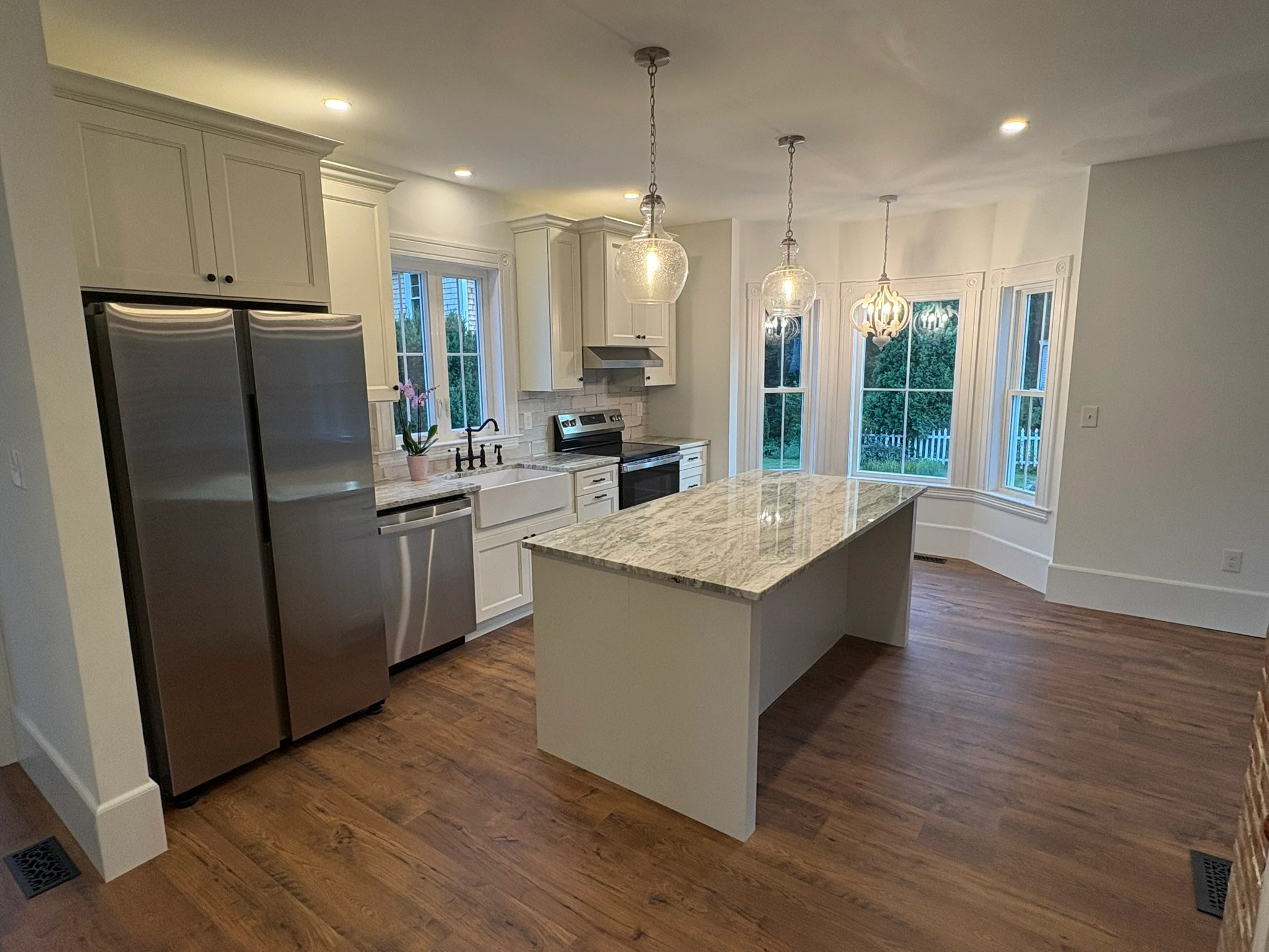 The restored kitchen — farmhouse sink and bay windows
