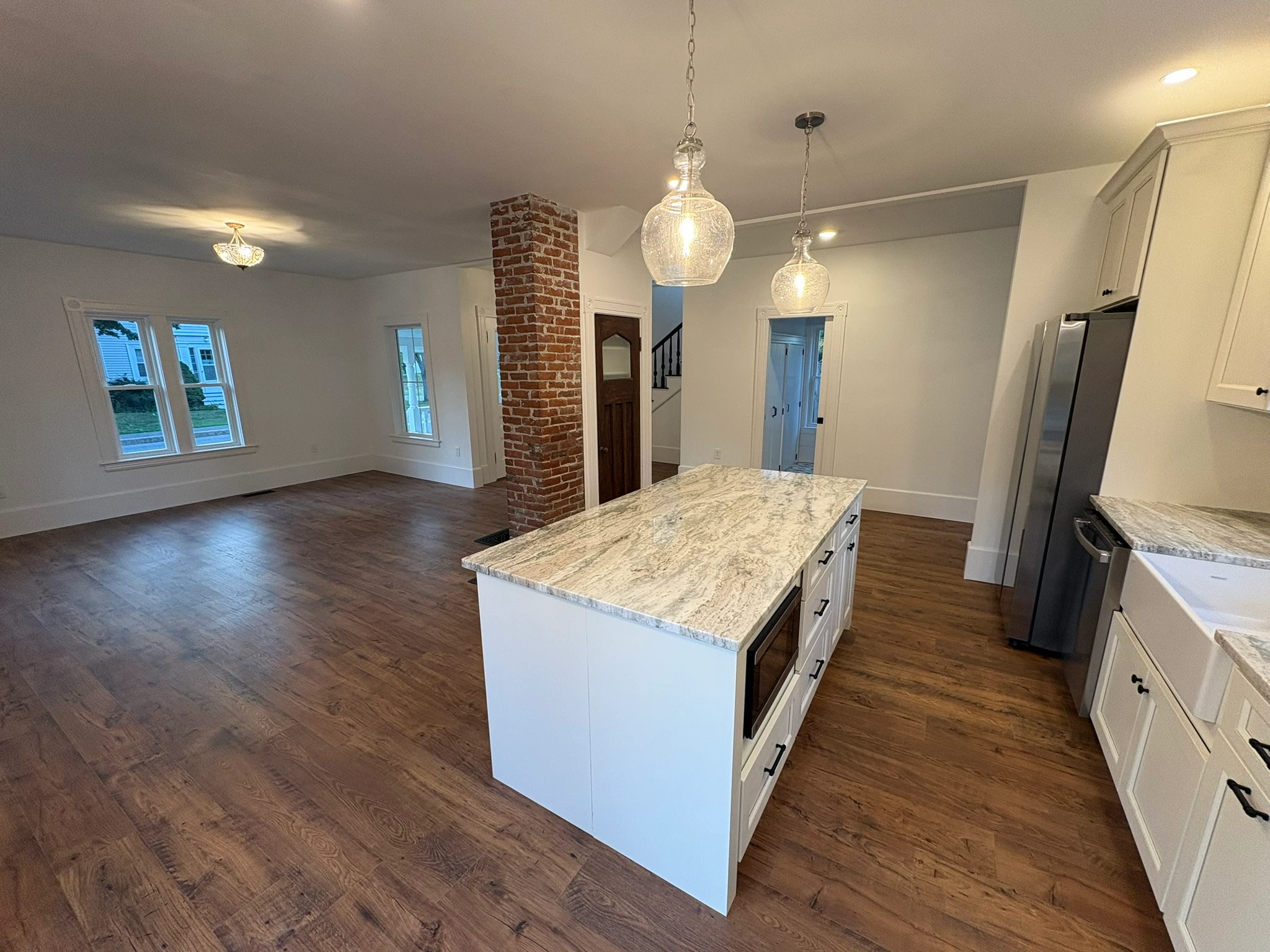 The open-plan main floor — island and brick column