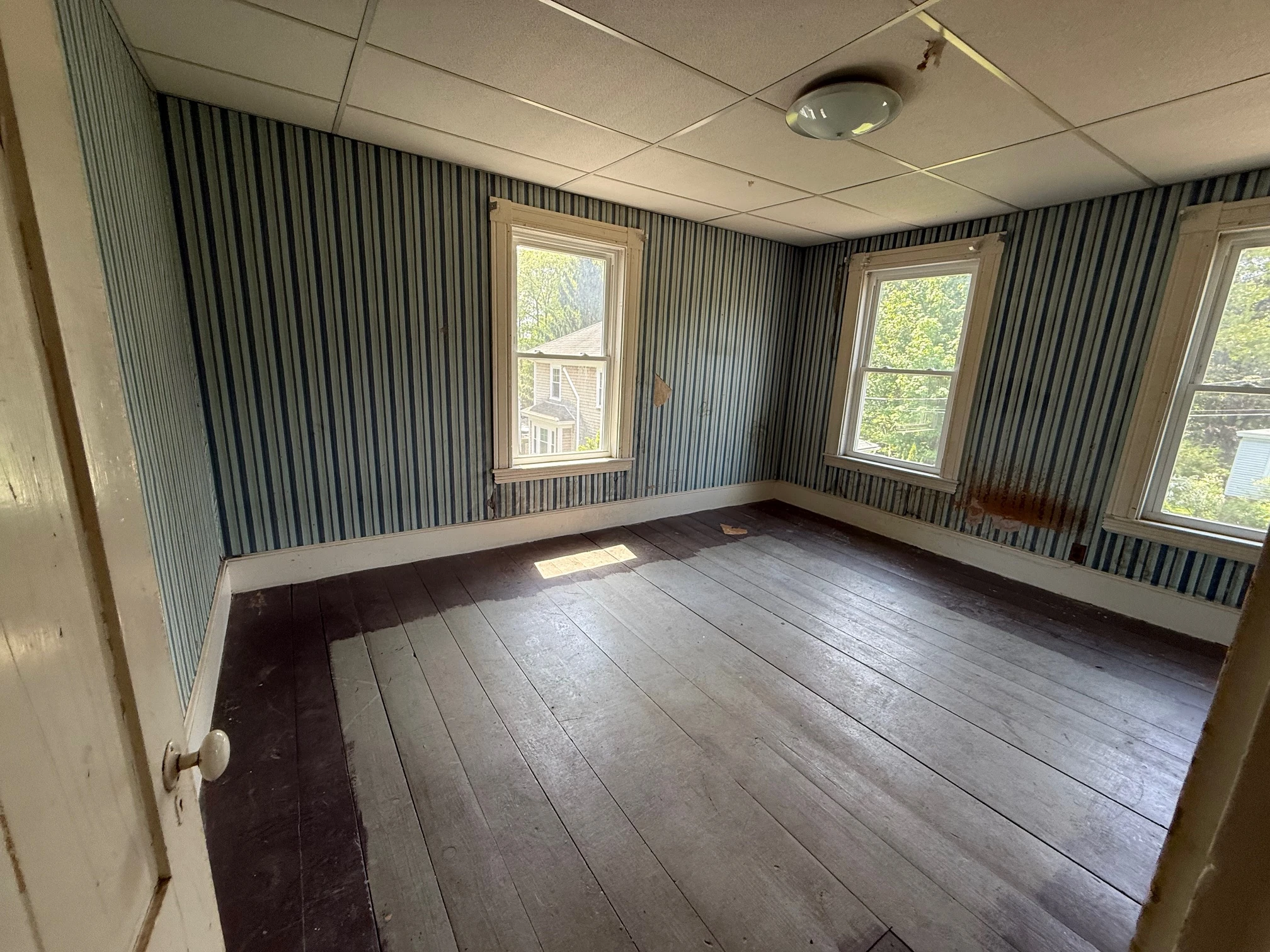 Unrestored bedroom with striped wall covering
