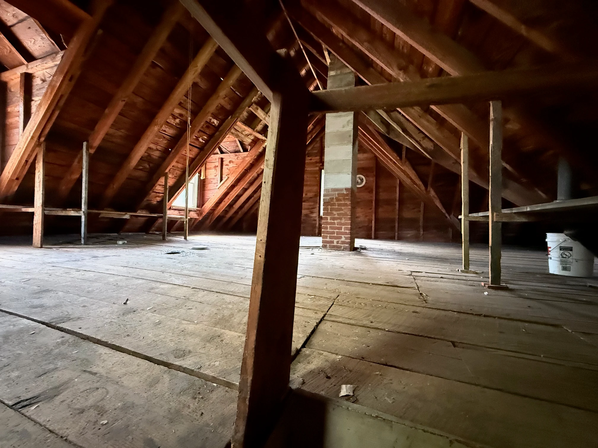 Raw attic with exposed rafters and chimney