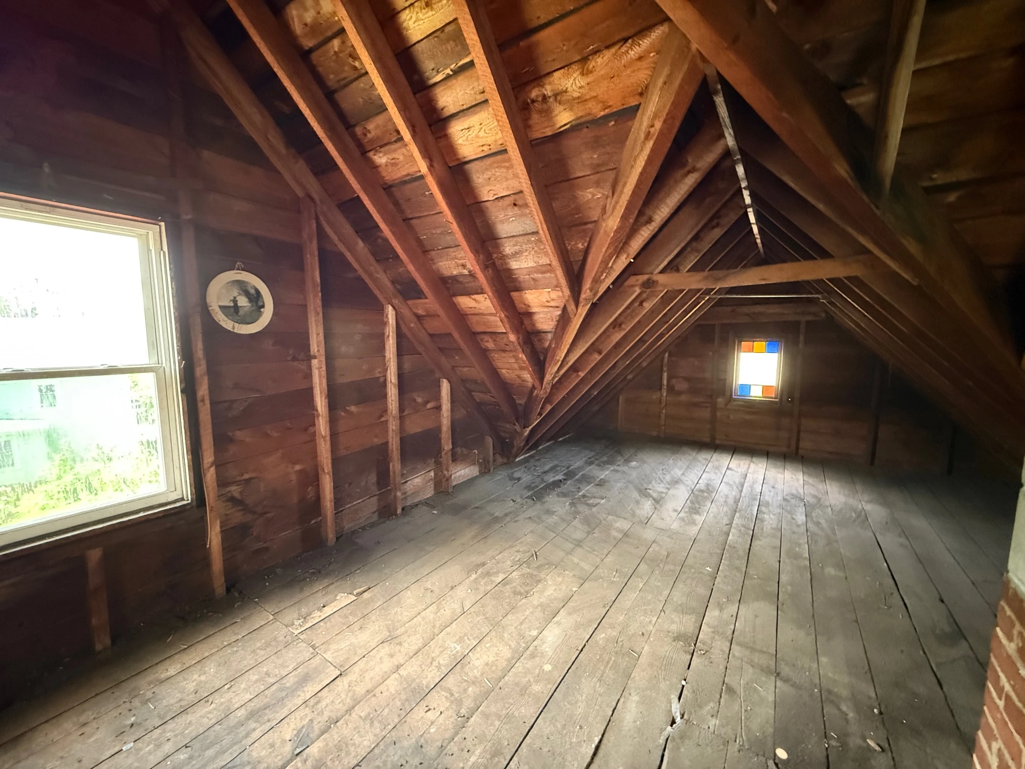 The raw attic — chimney and stained-glass window