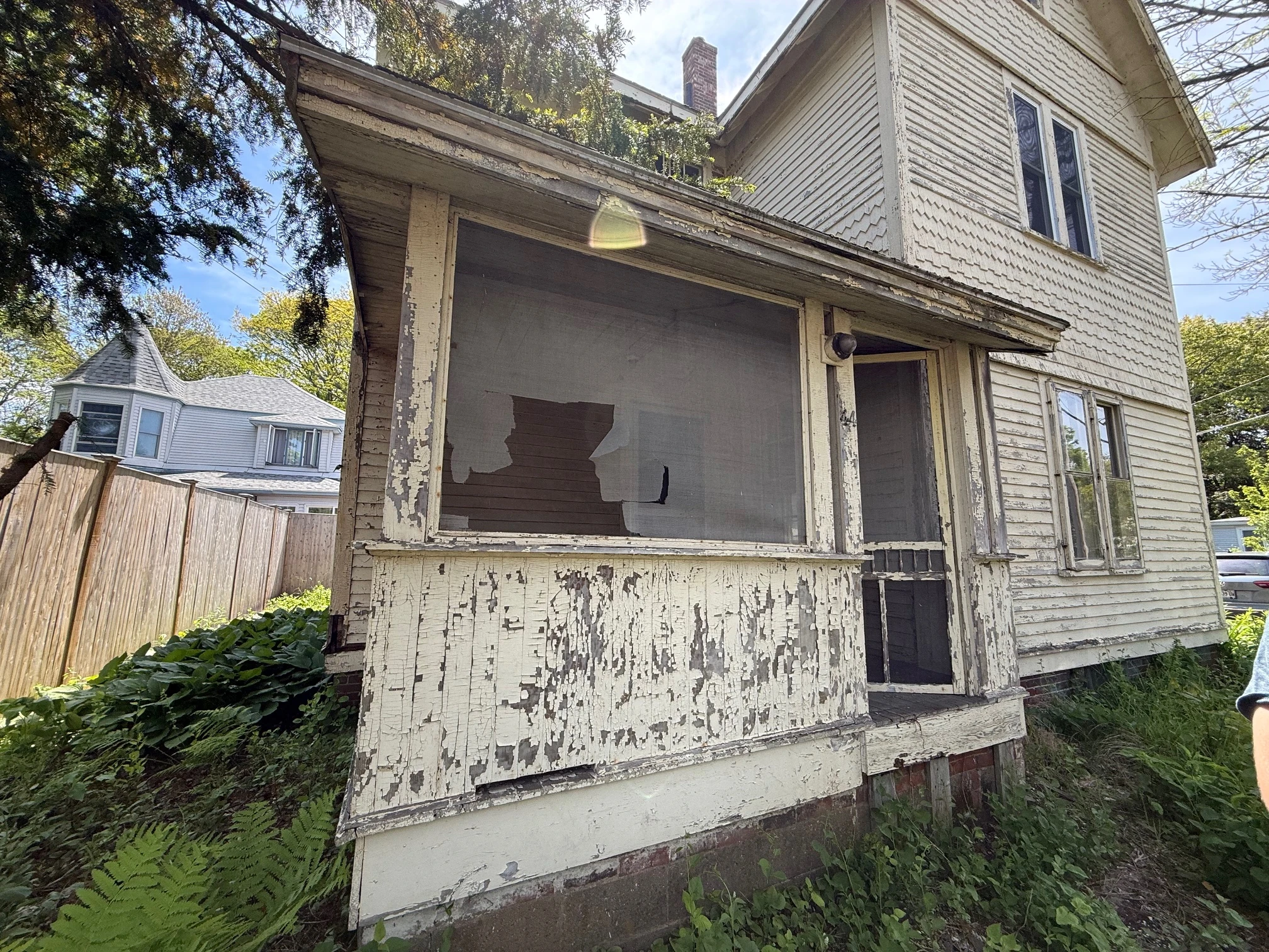 Old screened porch leaning against the south side